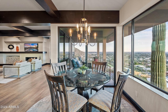 dining room with beamed ceiling, wood-type flooring, and a chandelier