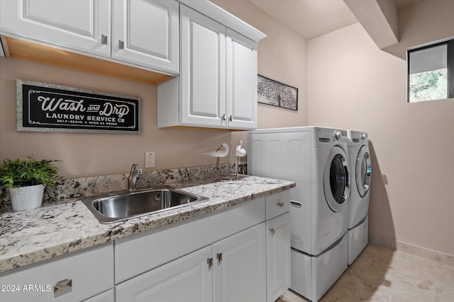 washroom featuring cabinets, independent washer and dryer, and sink