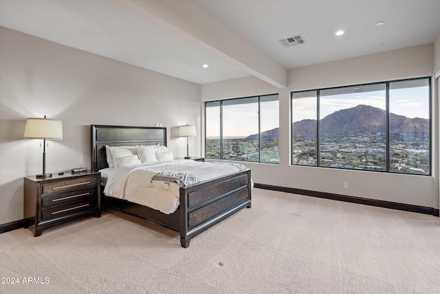 carpeted bedroom with a mountain view and beamed ceiling