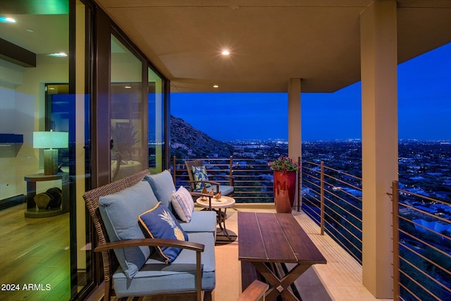 balcony at night featuring outdoor lounge area and a mountain view