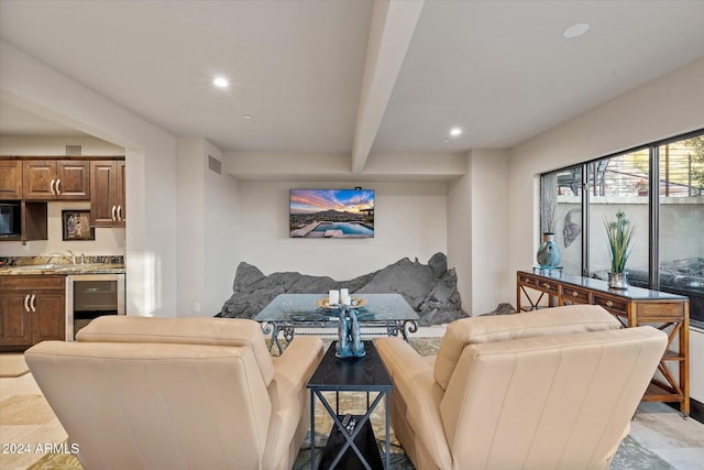 living room featuring beam ceiling, wine cooler, and sink