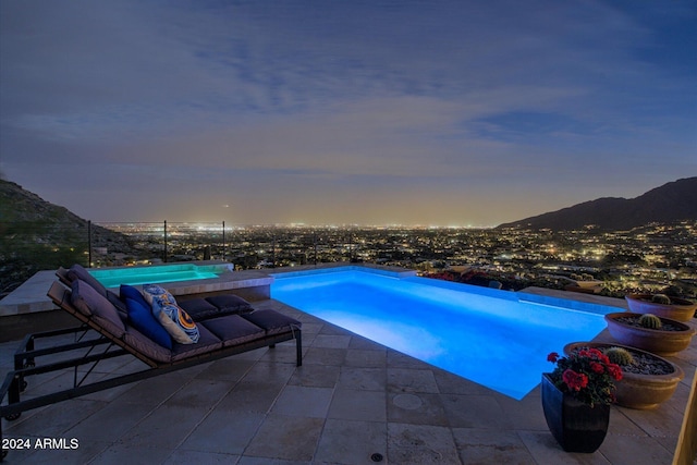 pool at dusk featuring a mountain view