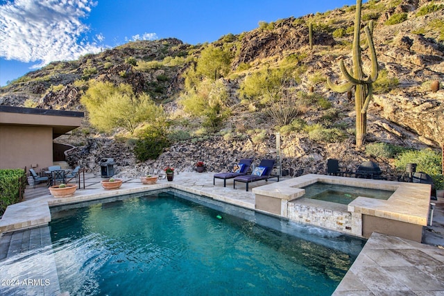 view of swimming pool with a mountain view, a patio area, an in ground hot tub, and grilling area