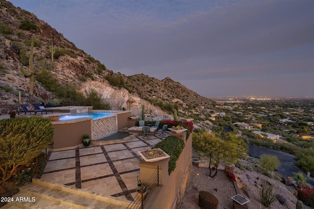 patio terrace at dusk featuring a mountain view