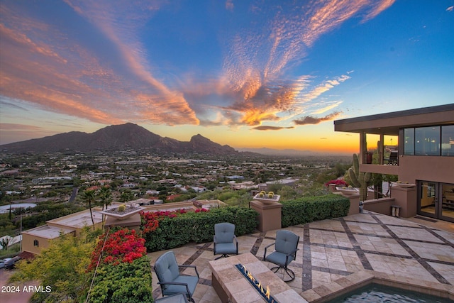 patio terrace at dusk featuring a mountain view