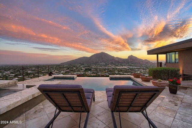 patio terrace at dusk featuring a mountain view