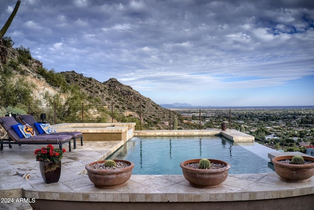 view of swimming pool featuring a mountain view and a patio