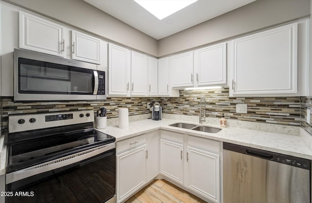 8141 N Central Ave Unit 9, Phoenix, AZ 85020 - kitchen featuring appliances with stainless steel finishes, a sink, white cabinetry, and tasteful backsplash