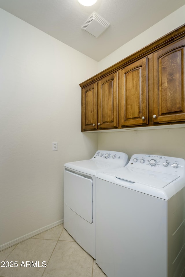 washroom with light tile patterned floors, visible vents, baseboards, cabinet space, and independent washer and dryer