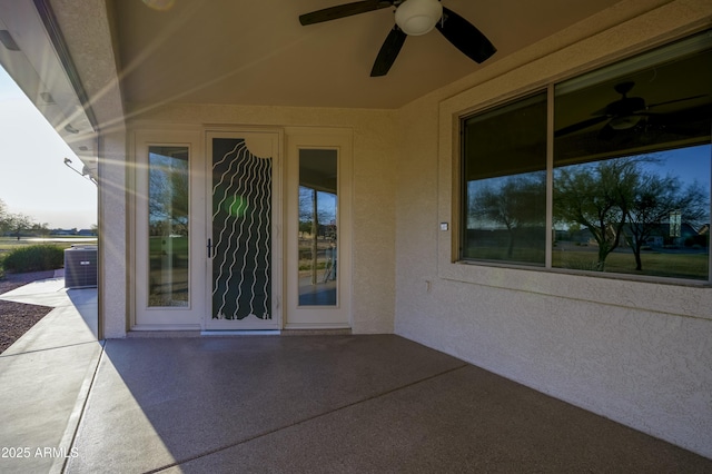 property entrance with a patio, a ceiling fan, and stucco siding