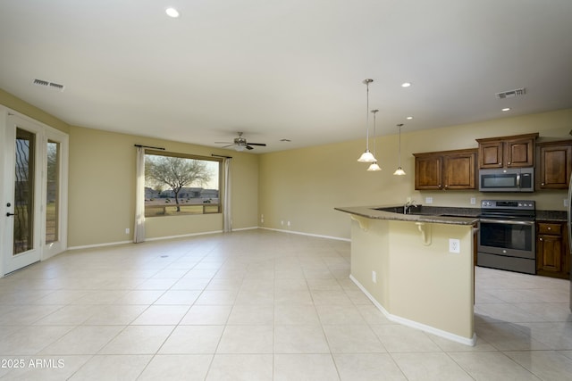 kitchen featuring light tile patterned floors, visible vents, a kitchen bar, and appliances with stainless steel finishes