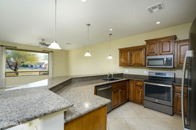 kitchen featuring visible vents, a sink, light stone counters, stainless steel appliances, and light tile patterned flooring