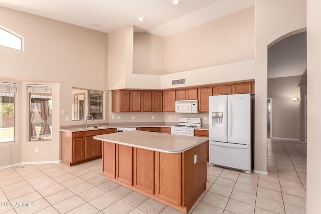 2230 E Whitten St, Chandler, AZ 85225 - kitchen with white appliances, a towering ceiling, arched walkways, light countertops, and light tile patterned floors
