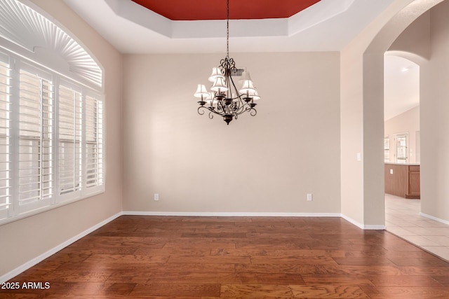 2230 E Whitten St, Chandler, AZ 85225 - unfurnished room with a chandelier, arched walkways, wood finished floors, and a tray ceiling