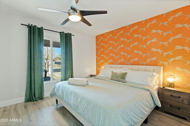 bedroom with baseboards, ceiling fan, wood finished floors, and wallpapered walls