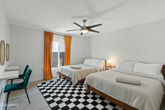 bedroom with light wood finished floors, ceiling fan, and baseboards