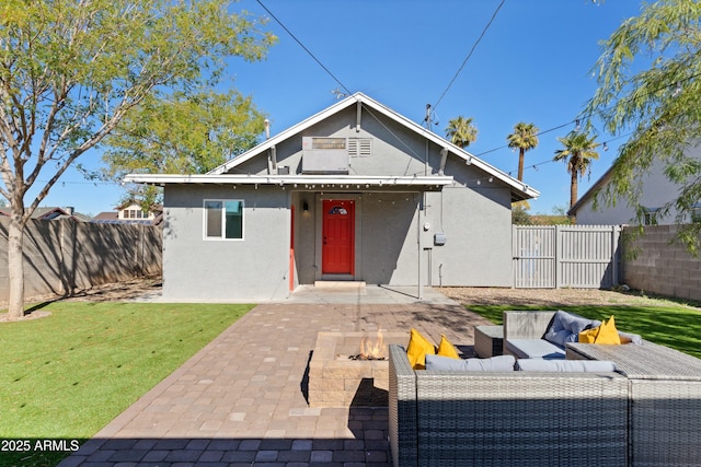 view of front of house with an outdoor living space with a fire pit, a fenced backyard, a patio, and stucco siding