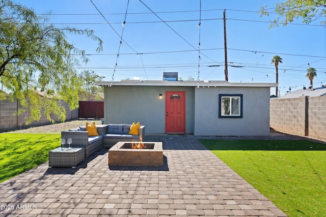 view of outdoor structure featuring a fenced backyard and an outdoor living space with a fire pit