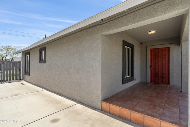 exterior space featuring a patio, fence, and stucco siding