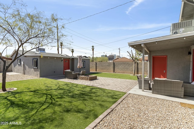 view of yard featuring an outdoor living space with a fire pit, a patio, a fenced backyard, and an outdoor structure