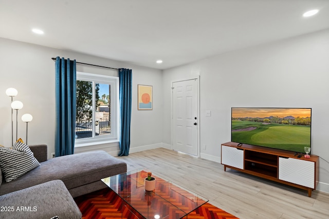 living area featuring baseboards, wood finished floors, and recessed lighting