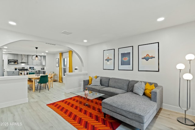 living room featuring arched walkways and recessed lighting