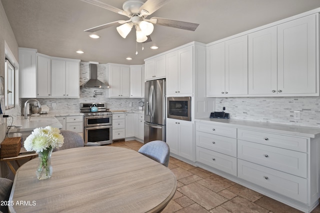 1185 S Camino Cobre Dr, Wickenburg, AZ 85390 - kitchen with a sink, ceiling fan, backsplash, wall chimney range hood, and appliances with stainless steel finishes