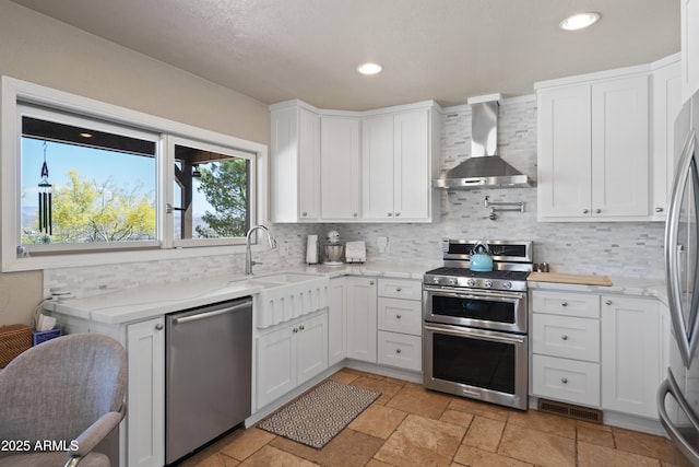 1185 S Camino Cobre Dr, Wickenburg, AZ 85390 - kitchen featuring a sink, wall chimney range hood, decorative backsplash, and appliances with stainless steel finishes