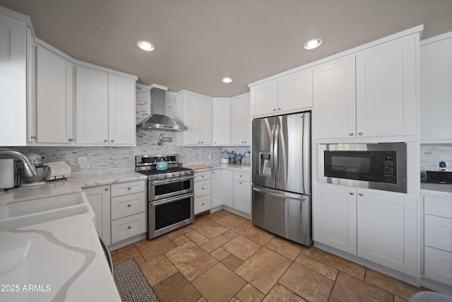1185 S Camino Cobre Dr, Wickenburg, AZ 85390 - kitchen featuring a sink, wall chimney range hood, appliances with stainless steel finishes, decorative backsplash, and recessed lighting
