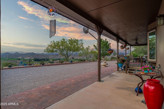 1185 S Camino Cobre Dr, Wickenburg, AZ 85390 - patio terrace at dusk featuring a ceiling fan and a mountain view
