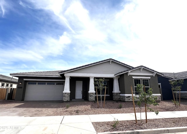 craftsman-style home featuring an attached garage, stucco siding, stone siding, and decorative driveway