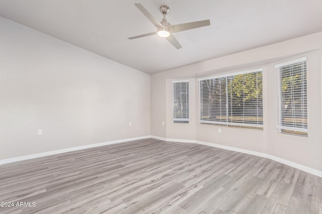 spare room with ceiling fan, light hardwood / wood-style floors, and vaulted ceiling