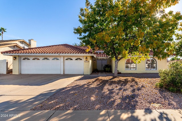 3315 E Hampton Ave, Mesa, AZ 85204 - view of front of home with a tile roof, an attached garage, concrete driveway, and brick siding