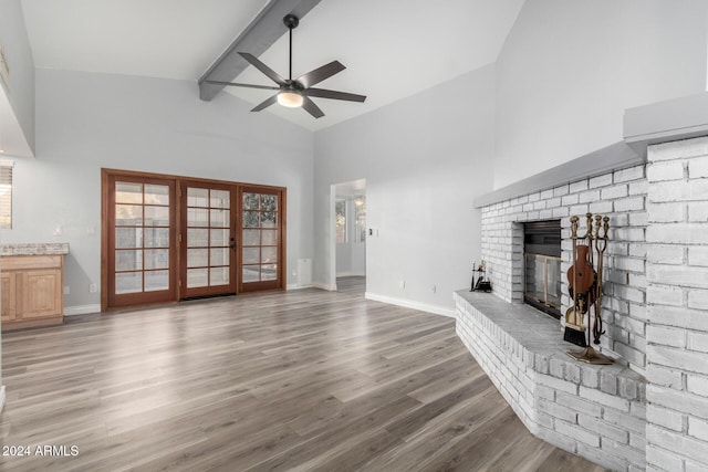 3315 E Hampton Ave, Mesa, AZ 85204 - unfurnished living room featuring a ceiling fan, a fireplace, beam ceiling, light wood-type flooring, and high vaulted ceiling