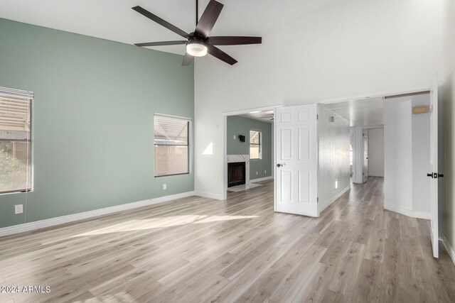 3315 E Hampton Ave, Mesa, AZ 85204 - spare room featuring high vaulted ceiling, a ceiling fan, light wood-style floors, and a high end fireplace