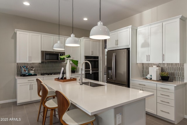 27647 N 176th Dr, Surprise, AZ 85387 - kitchen with stainless steel appliances, a sink, tile patterned flooring, tasteful backsplash, and white cabinetry