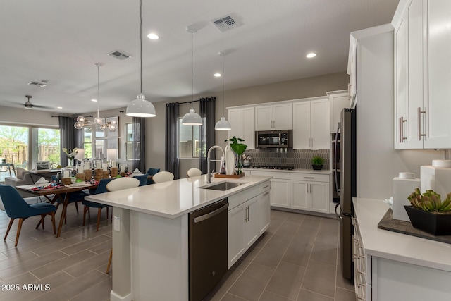 27647 N 176th Dr, Surprise, AZ 85387 - kitchen with a sink, stainless steel appliances, open floor plan, decorative backsplash, and white cabinetry