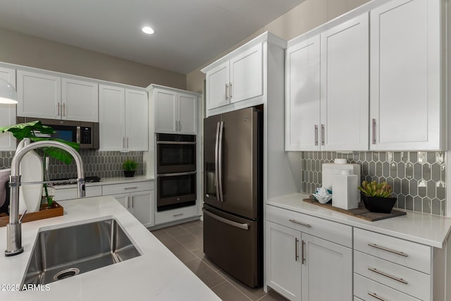 27647 N 176th Dr, Surprise, AZ 85387 - kitchen with appliances with stainless steel finishes, a sink, decorative backsplash, light countertops, and white cabinetry