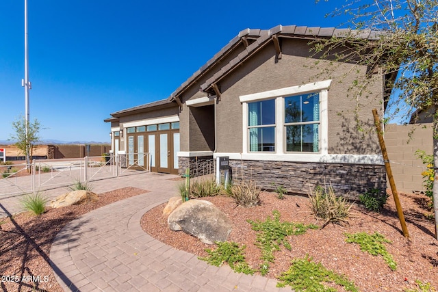 27647 N 176th Dr, Surprise, AZ 85387 - view of front of home with stone siding, stucco siding, a gate, and an attached garage