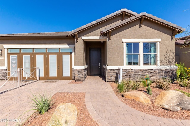 27647 N 176th Dr, Surprise, AZ 85387 - view of front of home featuring french doors, stone siding, and stucco siding