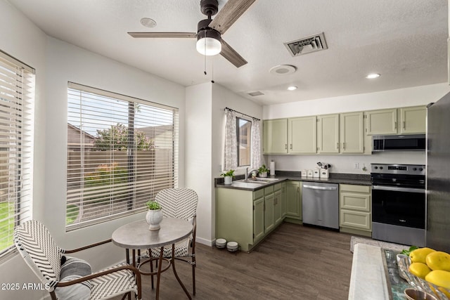 kitchen featuring sink, dark wood-type flooring, stainless steel appliances, and green cabinetry