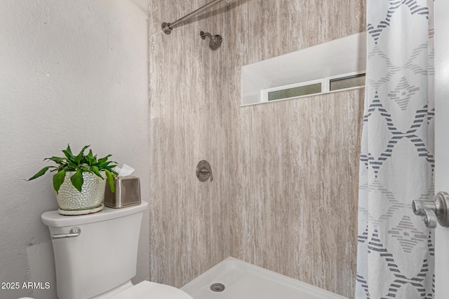 bathroom featuring a shower with curtain and toilet