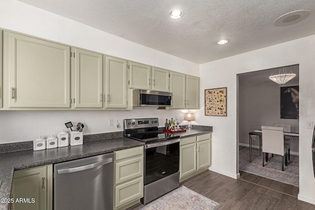 kitchen featuring a textured ceiling, dark hardwood / wood-style floors, stainless steel appliances, and green cabinetry