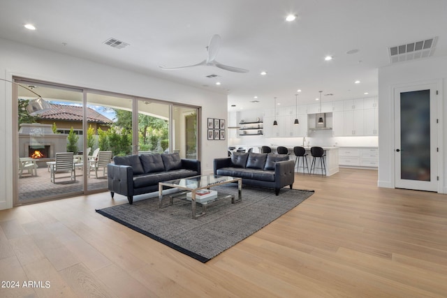 living room featuring light wood-type flooring and ceiling fan