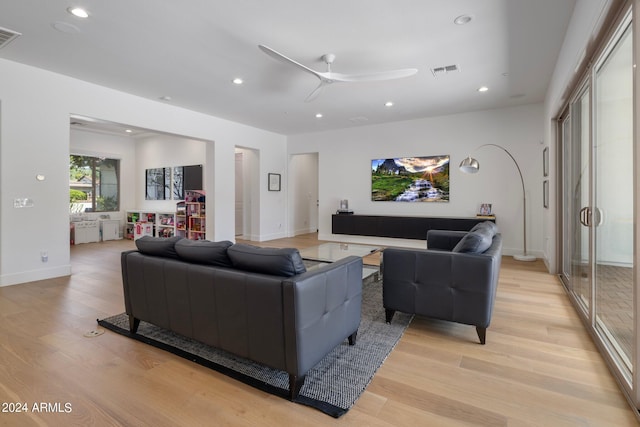 living room featuring ceiling fan and light hardwood / wood-style floors