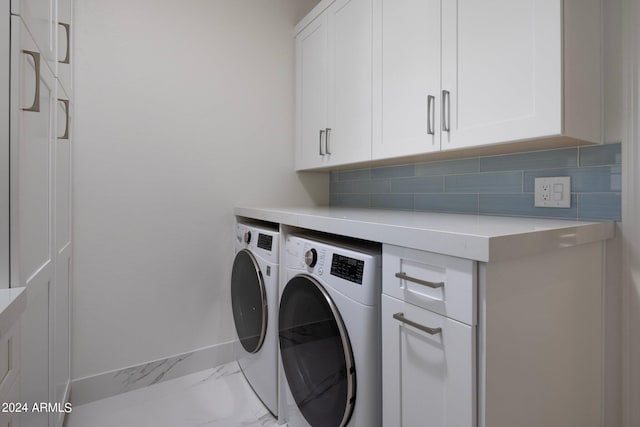 clothes washing area featuring cabinets and washing machine and dryer