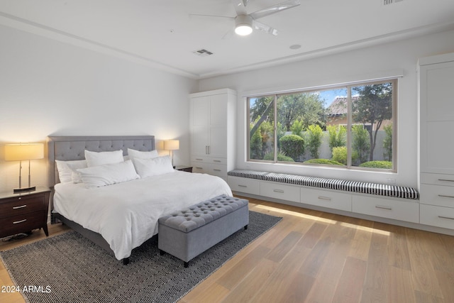 bedroom featuring crown molding, light hardwood / wood-style flooring, and ceiling fan