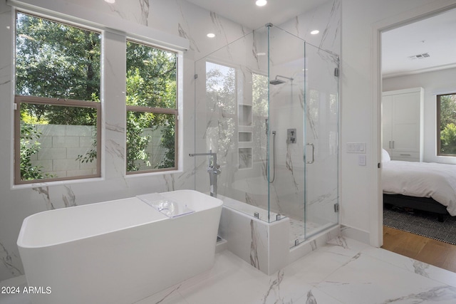 bathroom with independent shower and bath and a healthy amount of sunlight