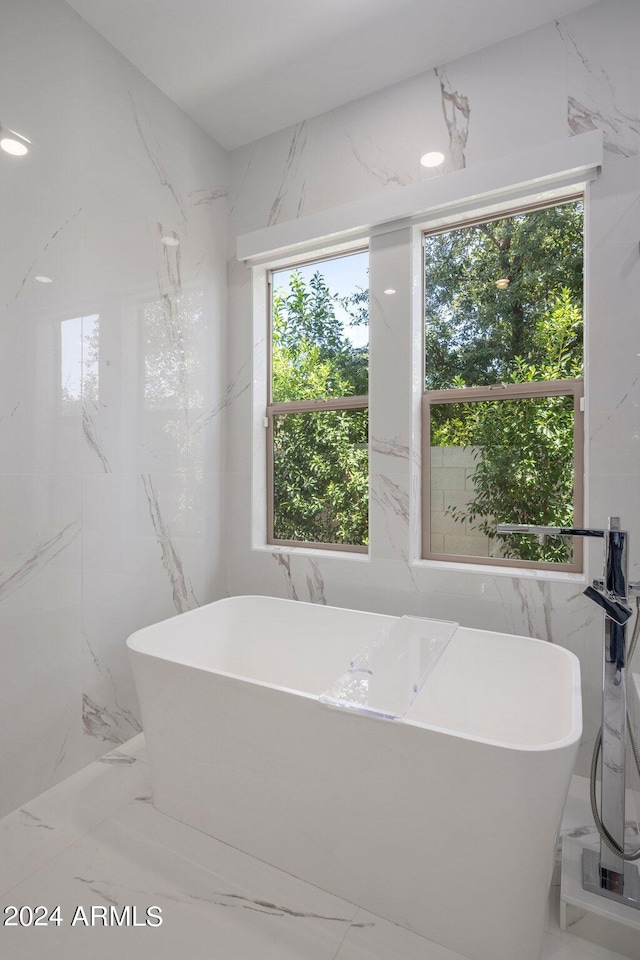 bathroom featuring a healthy amount of sunlight and a bathtub