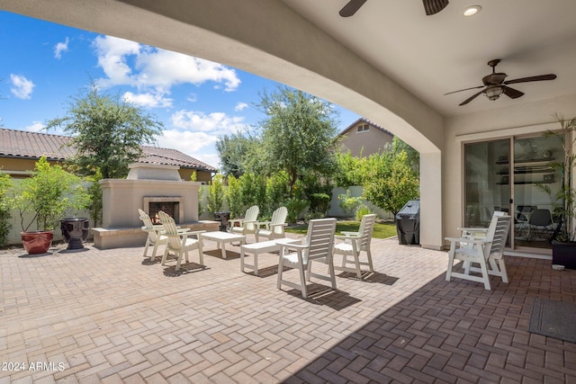 view of patio with grilling area, ceiling fan, and exterior fireplace